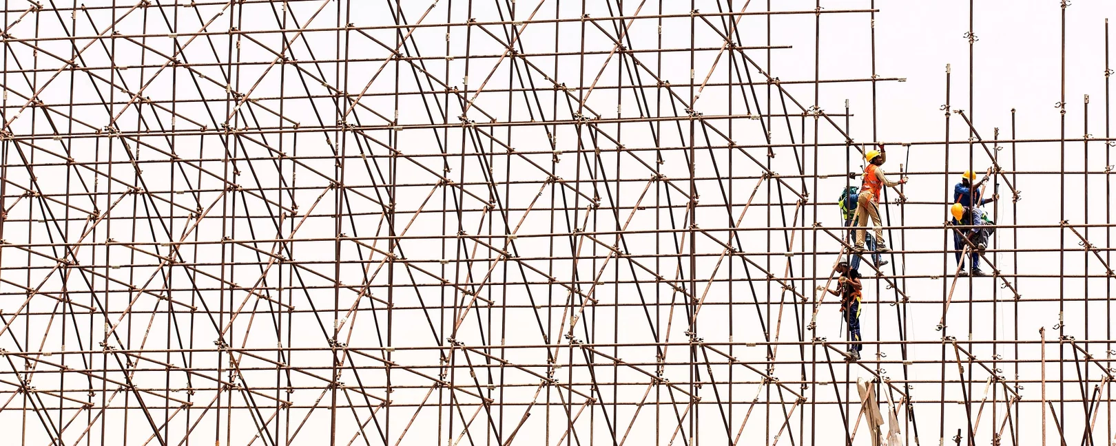 großes Baugerüst, dass drei Personen gerade aufbauen