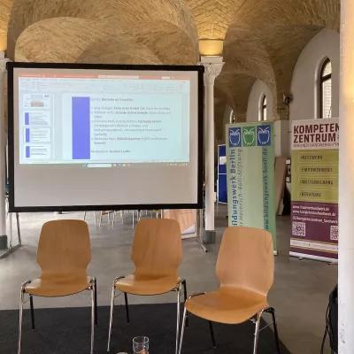 Bild zeigt Präsentationsleinwand und Aufsteller der Veranstalter